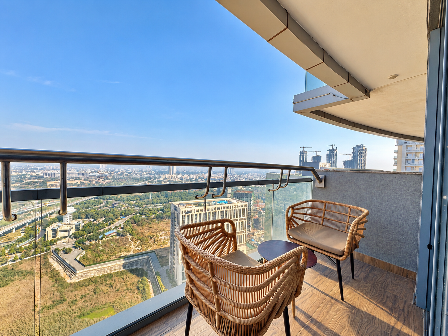 Sunlit city skyline from the balcony at Panorama Balcony 32, floor 32 of Supernova Spira, Noida