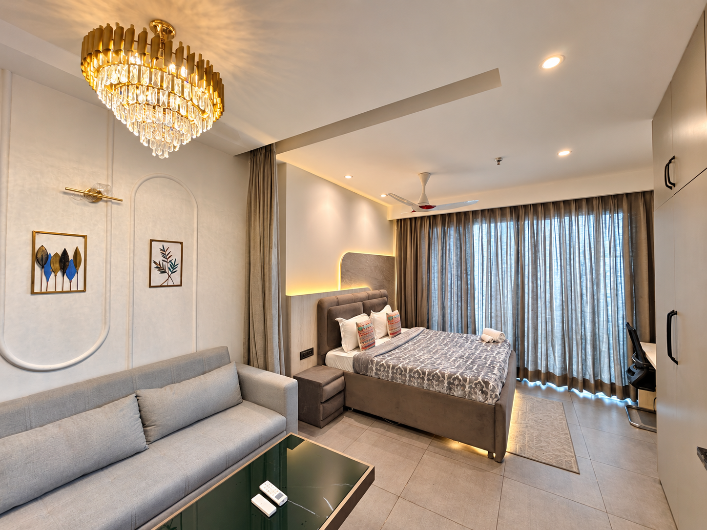 Living area with gold chandelier and sofa at Panorama Balcony 32, Supernova Spira room booking