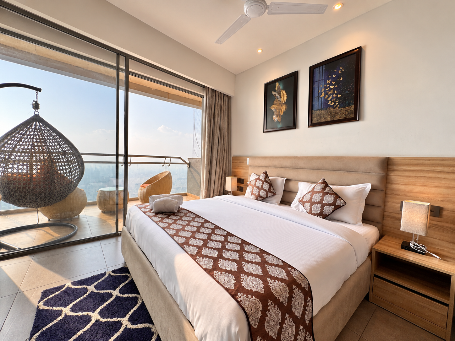 Bedroom with hanging chair balcony view at RiverCrest 39, a room in Supernova Noida