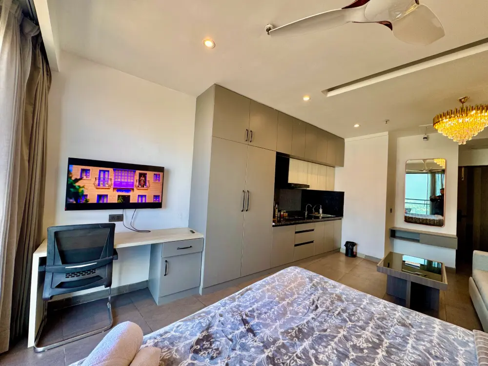 bedroom with smart TV and city view at Panorama 32 Supernova Noida