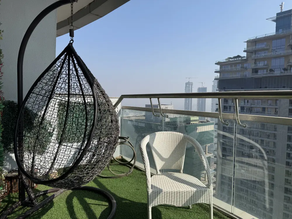 Balcony with swing chair and city view at Mulberry Homes Supernova Noida