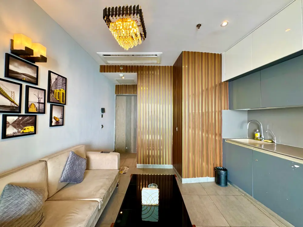 Kitchen with wooden cabinets at Mulberry Homes Supernova Noida