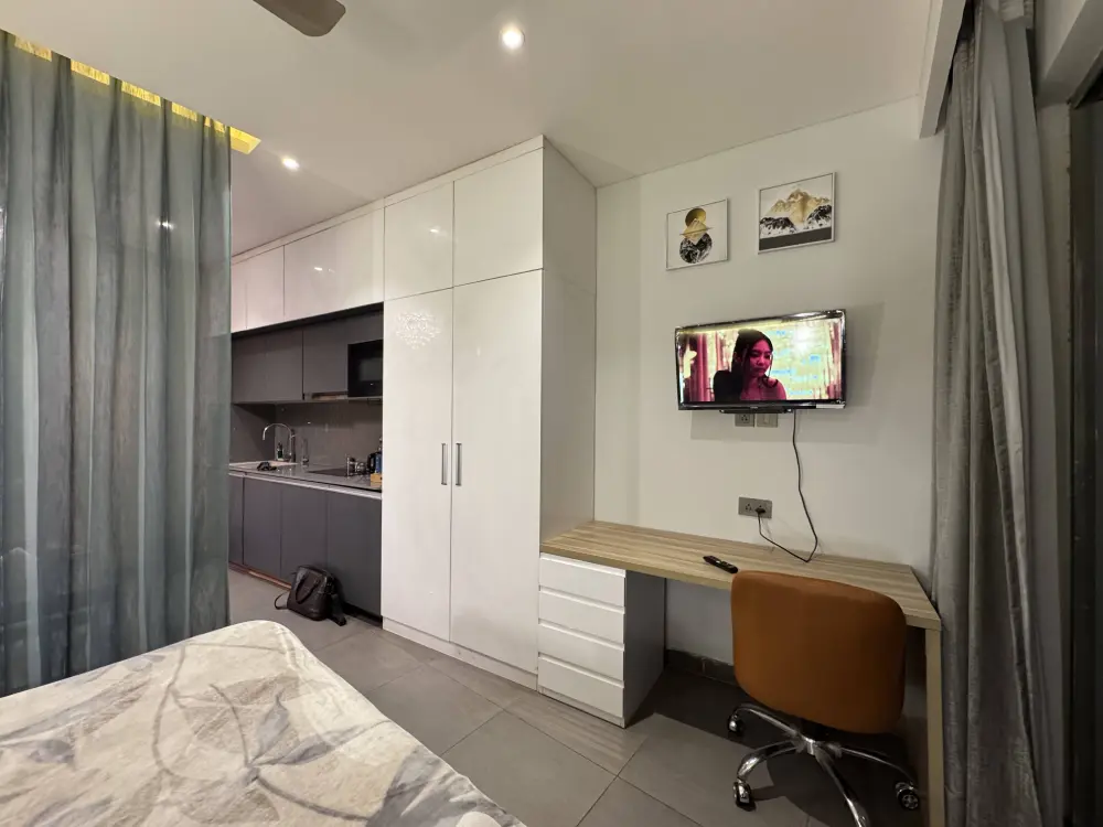 minimalist bedroom with TV at Mulberry Homes Supernova Noida