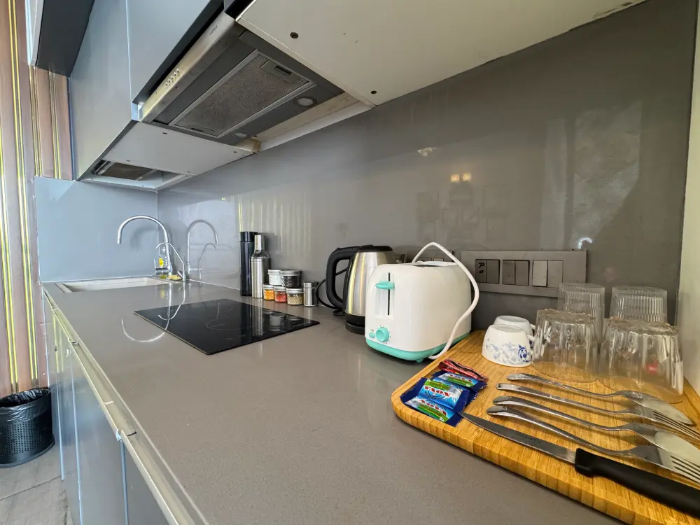 Modern kitchen with chimney in UrbanAura 37 studio apartment Noida