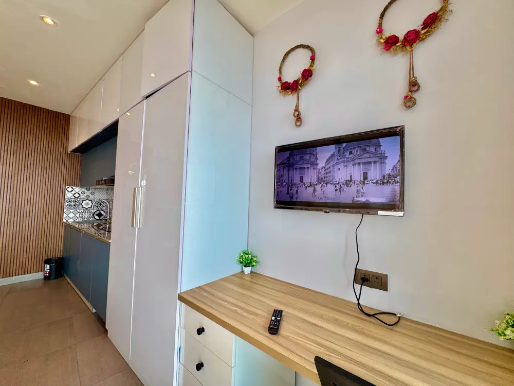Supernova 94 Spira Noida – Eleve 31 bedroom with wall-mounted smart TV, wooden panel backdrop and river-facing window