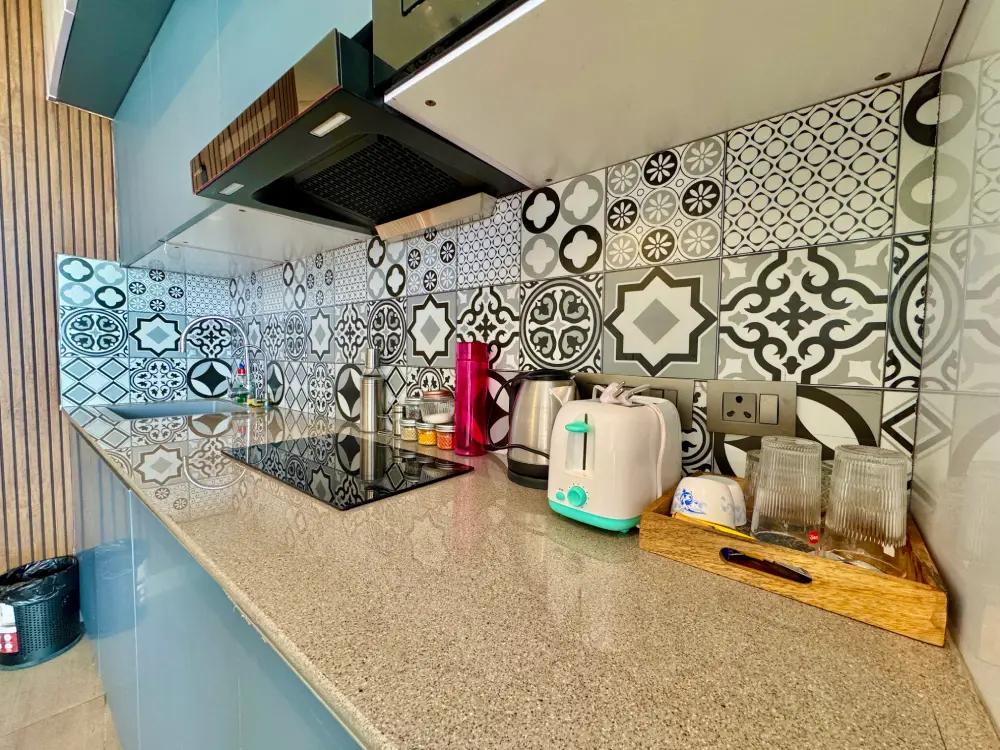	Supernova 94 Noida – Eleve 31 modular kitchen with black countertop, floral tile backsplash and premium appliances at Spira