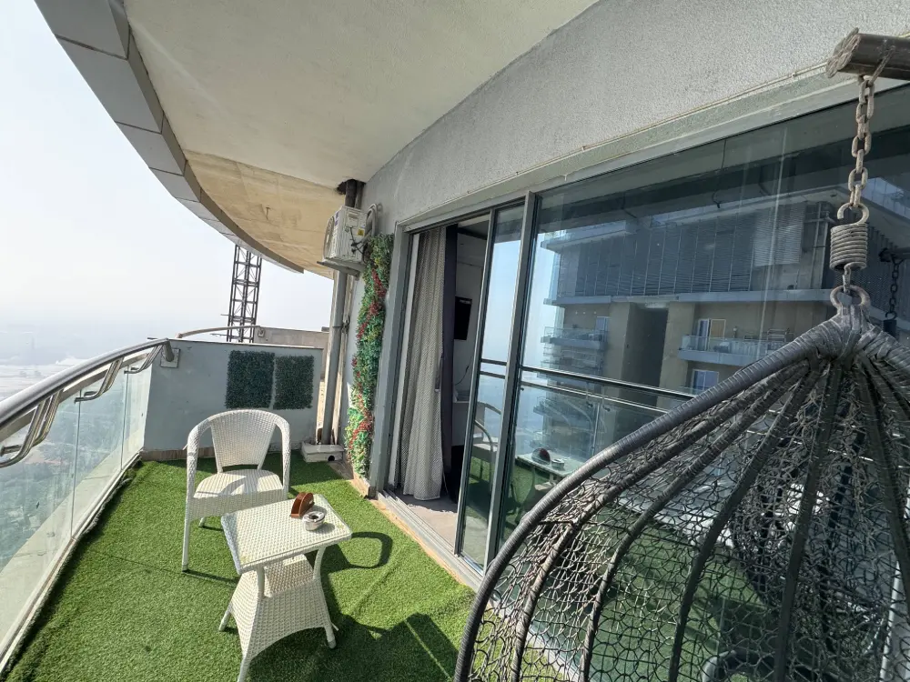 High-rise balcony with chairs at Mulberry Homes Supernova Spira Noida