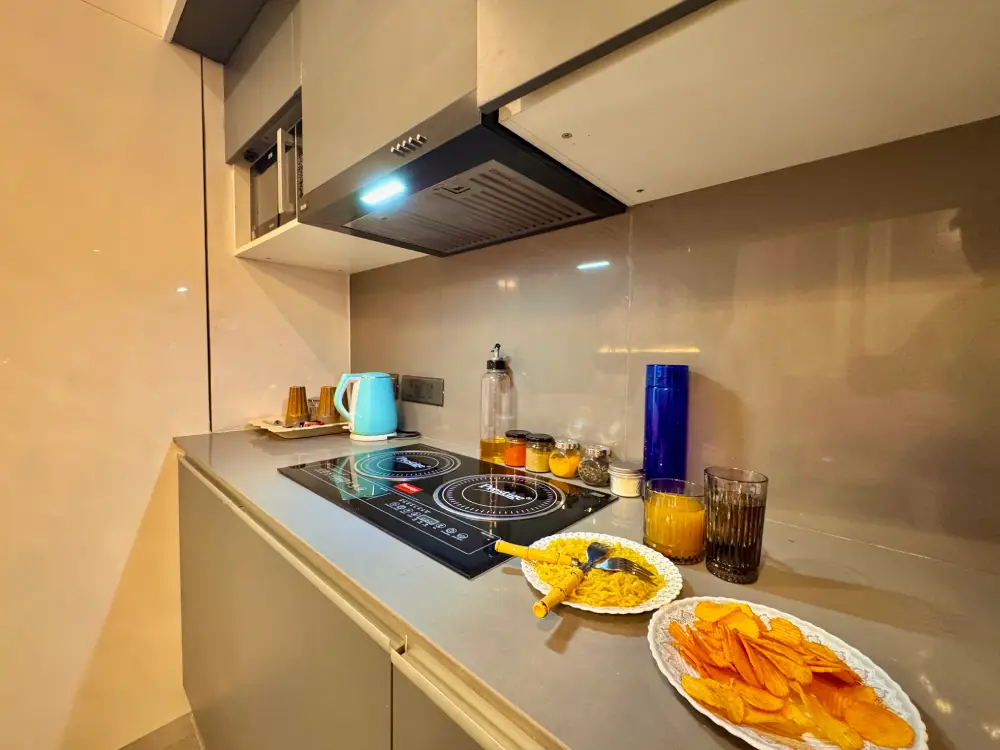 Open kitchen and living room at Supernova Noida Airbnb Mulberry Homes