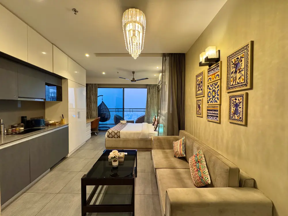 Compact studio room with TV in Supernova MulberryHomes apartment Noida