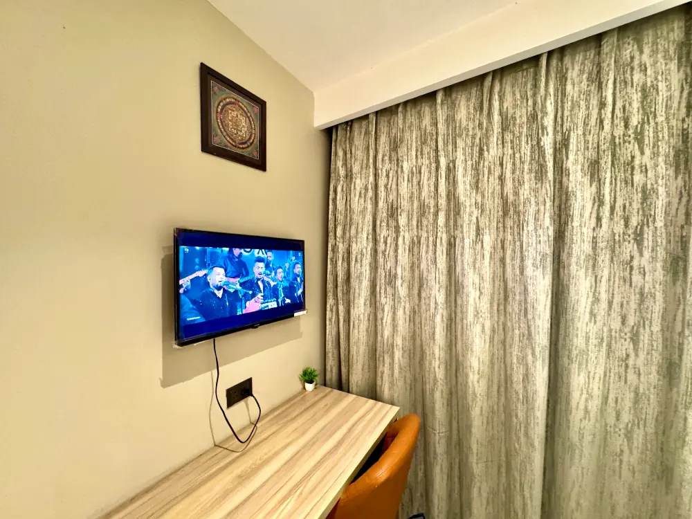 Stylish room with TV and curtains in Supernova 94 Noida apartment