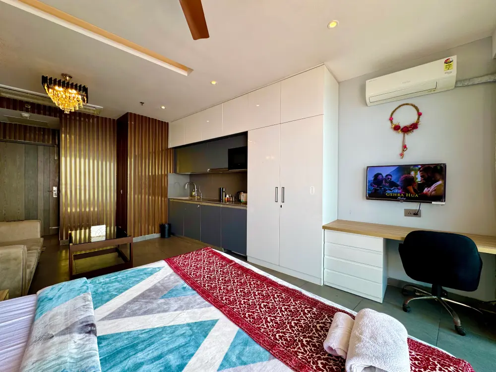 UrbanAura 37 river view studio apartment living area with TV in Supernova Noida